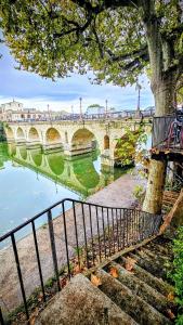 a bridge over a river with a tree and stairs at Maison blanche in Calvisson