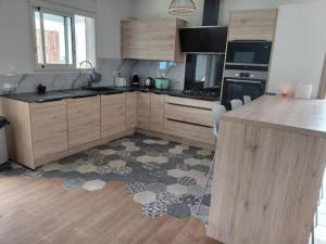 a kitchen with wooden cabinets and a rug on the floor at Ti Kaz Salazie 2 in Salazie