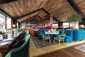 a restaurant with blue couches and tables and chairs at Fyri Tunet Hemsedal in Hemsedal