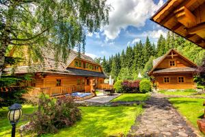 a large wooden house with a yard and a house at Pinius by Hotel Pieris in Pribylina +44 photos