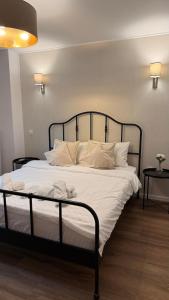 a bedroom with a bed with white sheets and pillows at Tudor's apartment in Bucharest