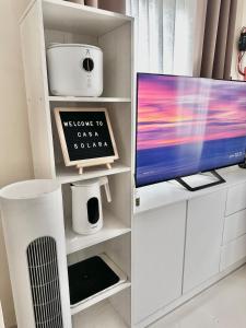 a living room with a tv and a white shelf at Casa Solara in General Santos