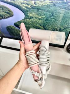 a hand holding a pink phone in front of a monitor at Casa Solara in General Santos