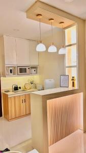 a kitchen with white cabinets and a counter with lights at Casa Solara in General Santos