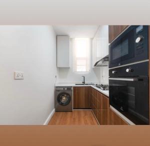 a kitchen with a stove and a washer and dryer at Home helpers in Lagos
