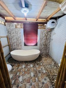 a bathroom with a large tub and a toilet at Villa Lakdu in Sorongjukung