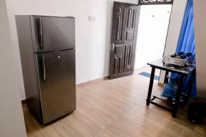 a stainless steel refrigerator in a room with a table at Arunella Beach Villa in Tangalle