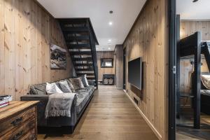 a living room with a couch and a staircase at Fyri Tunet Hemsedal in Hemsedal