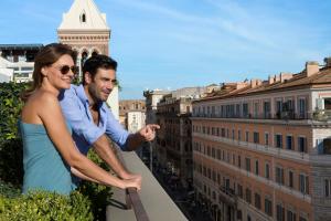 d'un homme et d'une femme se tenant sur le fond d'un bâtiment dans l'établissement Hotel Artemide, à Rome
