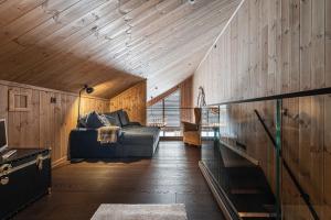 a living room with a couch in a wooden ceiling at Fyri Tunet Hemsedal in Hemsedal