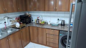 a kitchen with a sink and a washing machine at Elegant Double Room in Abu Dhabi