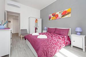 ein Schlafzimmer mit einem Bett mit einer lila Tagesdecke in der Unterkunft Lilli Home Holidays in Rom
