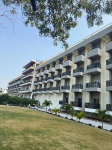 an apartment building with a lawn in front of it at Firefox Hotel and Resort in Moinabad