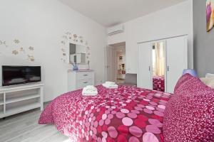 ein Schlafzimmer mit einem rosa Bett mit rosa Kissen in der Unterkunft Lilli Home Holidays in Rom