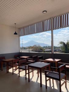 a restaurant with tables and chairs and a large window at NIRAN Hotel & Residence in Ban Talai