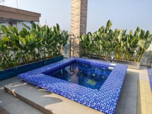 a blue tile pool on a balcony with plants at Hotel Elite Palace in Comilla