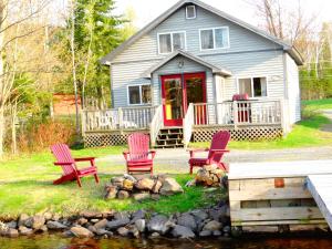 una casa con cuatro sillas rojas delante de ella en Gray Ghost Camps, en Rockwood