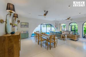 a kitchen and living room with a table and chairs at StayVista at Casa Roma - Private Pool in Siolim