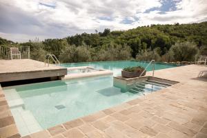 a large swimming pool with blue water in a yard at Agriturismo La Romagnana in Pistoia