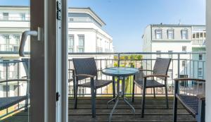 a patio with chairs and a table on a balcony at Villa Ahlbeck - Ferienwohnung Seestern in Ahlbeck