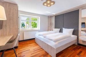a bedroom with a large white bed and a desk at Villa Ahlbeck - Ferienwohnung Seestern in Ahlbeck