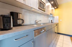 a kitchen with a sink and a microwave at Villa Ahlbeck - Ferienwohnung Seestern in Ahlbeck