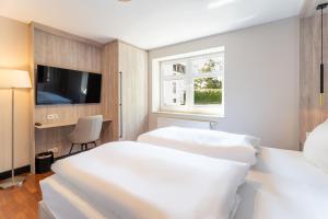 a hotel room with two beds and a tv at Villa Ahlbeck - Ferienwohnung Seestern in Ahlbeck +8 photos