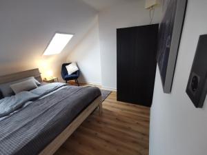 a bedroom with a bed and a chair in it at Moderne Ferienwohnung Iserlohn 1 in Iserlohn