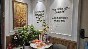a table with a plate of food and flowers on it at 루미에르스테이 in Ŭijŏngbu-yŏk