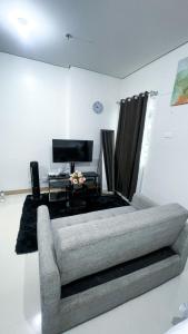 a living room with a couch and a television at Comfortable Studio Stay Made for Relaxation in Iloilo City +2 photos