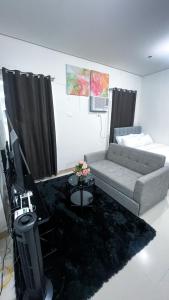 a living room with a couch and a television at Comfortable Studio Stay Made for Relaxation in Iloilo City