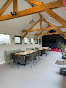 a room with wooden tables and chairs in a building at Treeline Cabins in Cădăreşti