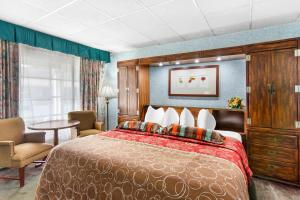 a hotel room with a bed and a table and chairs at Rodeway Inn Williamsburg Historic Area in Williamsburg +29 photos