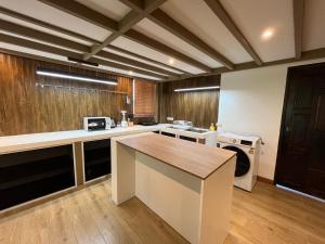 a large kitchen with a counter top in a room at Khao Lak - Loft Suite with 2 king size beds, bathroom with bathtub in Khao Lak