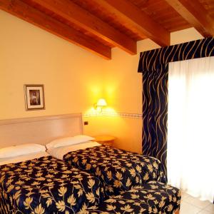 PegognagaにあるHotel Ristorante Novecentoのベッドと窓が備わるホテルルーム