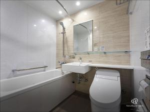 a bathroom with a sink and a toilet and a bath tub at Daiwa Roynet Hotel Yokohama-Koen in Yokohama