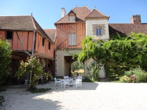a house with a table and chairs in the courtyard at Chateau Des Roises in Bucey-en-Othe