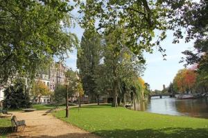 アムステルダムにあるPerfect APT - Heart of Amsterdamの木々や建物が立ち並ぶ川の横の公園