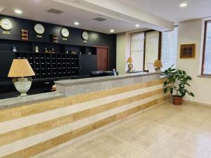 a lobby with a bar with clocks on the wall at Canyon Hills Hotel in Yerevan +26 photos