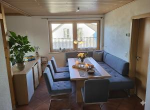 a living room with a blue couch and a table at Große Ferienwohnung nähe dem schönen Seenland in Merkendorf