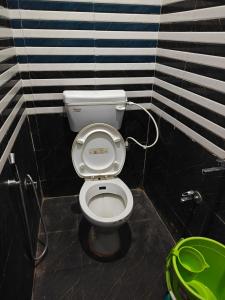 a bathroom with a white toilet in a stall at Shri Prabhu guest house in Ayodhya