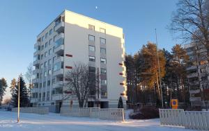 a tall white building with snow in front of it at Tilava ja elegantti kolmio in Kokkola