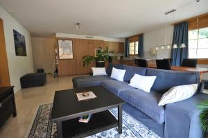 a living room with a blue couch and a table at Family Frame Apartment in Lauterbrunnen