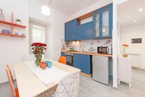 eine Küche mit blauen Schränken und einem Tisch mit Blumen in der Unterkunft Lilli Home Holidays in Rom