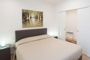 Un dormitorio con una cama blanca y una pintura en la pared en Le Dimore del Conte en Vicenza