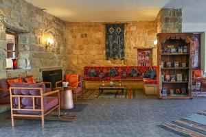 a living room filled with furniture and a stone wall at The Old Village Hotel & Resort in Wadi Musa