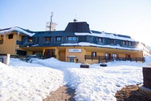 um edifício coberto de neve com neve à sua volta em Club Esse Pila 2000 em Pila