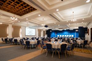 a banquet hall with tables and chairs and a screen at The Old Village Hotel & Resort in Wadi Musa +174 photos