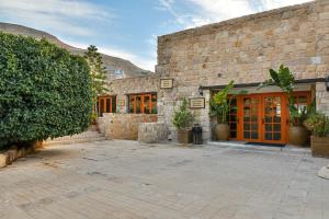a stone building with a courtyard with plants at The Old Village Hotel & Resort in Wadi Musa