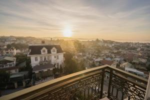 a view of a city at sunset from a balcony at Bee Luxury Dalat Hotel in Da Lat